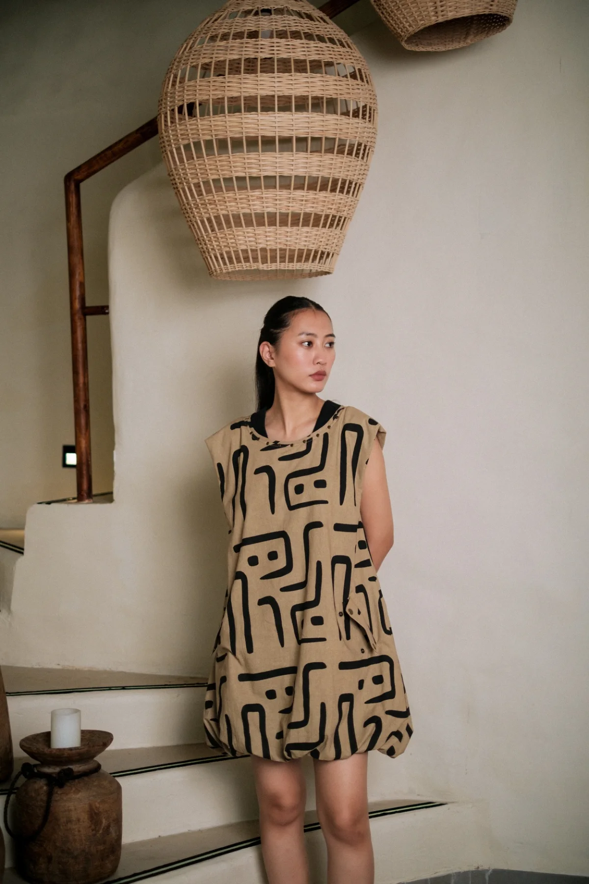 Model wearing a cream and black graphic shift dress indoors